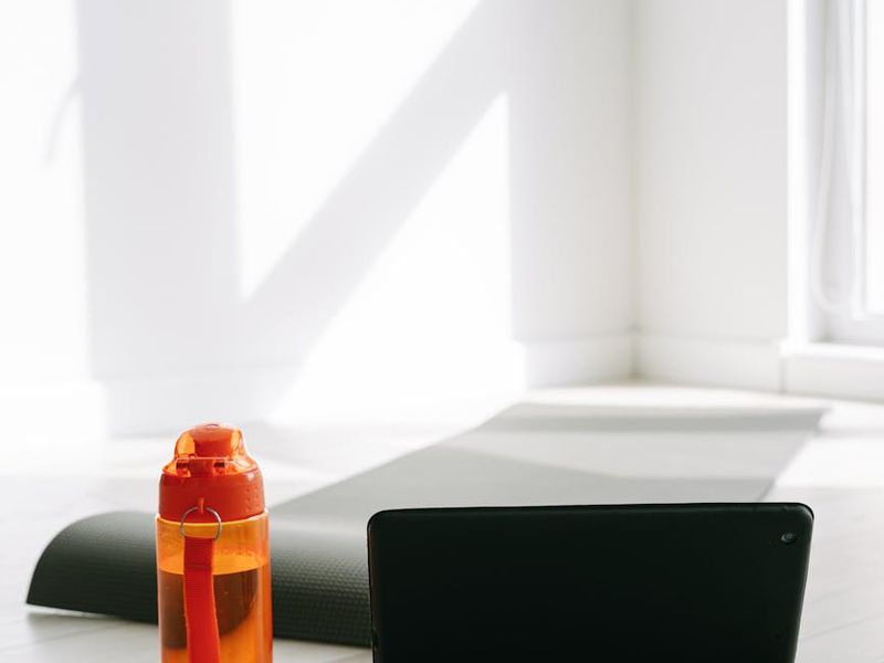 Close up of yoga mat and water bottle in sunlight.