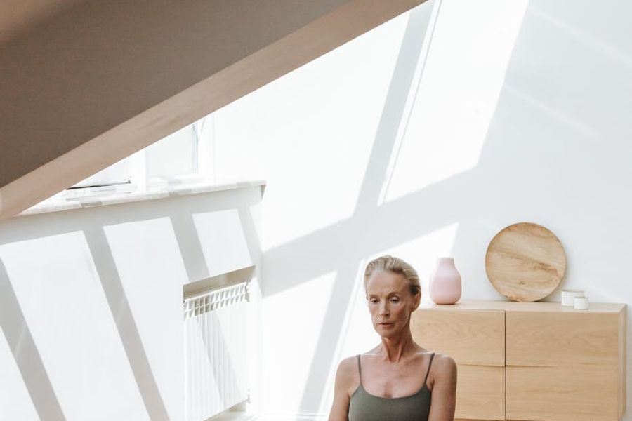 Person practicing yoga in a bright minimalistic studio room.